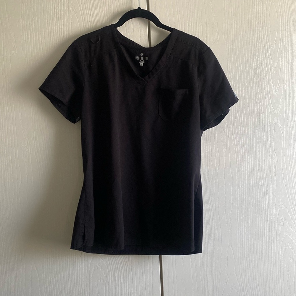 Black short sleeve scrub top with one pocket and a place to hang badges.